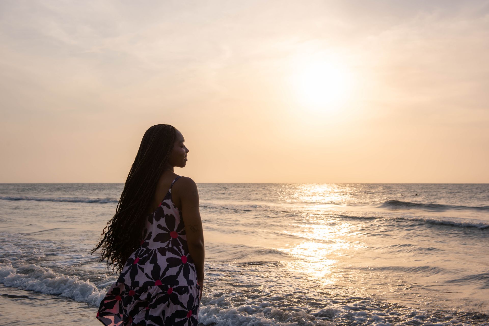 A woman with a sun-kissed glow on the beach at golden hour